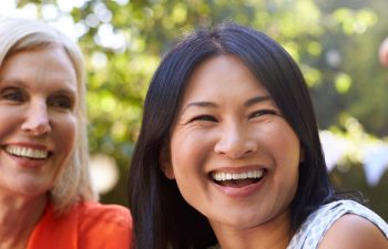 Mature Female Friends Socializing In Backyard Together