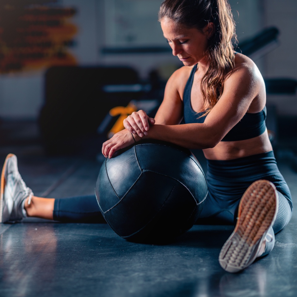Stretching after a gym workout, a woman promotes muscle recovery and flexibility. Structured stretches reduce soreness, enhancing comfort