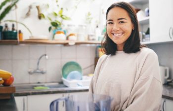 Woman, blender and portrait for smoothie in kitchen, self care or pride for drink, detox or diet at home. Person, milkshake and confident in house with appliance, weight loss or nutrition in Cambodia.