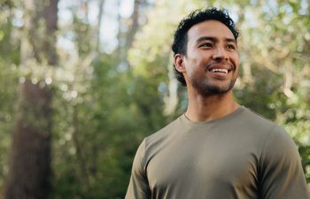 Thinking, happy or man in nature with hiking, fresh air or inspiration on trekking journey. Reflection, space or person in forest with satisfaction, mindfulness or daydreaming in outdoor adventure
