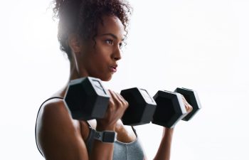 Breathing, dumbbells or woman in gym for fitness, strength challenge or bodybuilding for muscle growth. Flare, concentration or African athlete with weightlifting exercise, serious or training club.