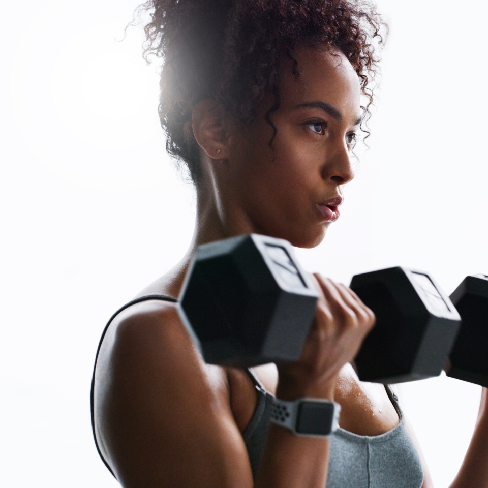 Breathing, dumbbells or woman in gym for fitness, strength challenge or bodybuilding for muscle growth. Flare, concentration or African athlete with weightlifting exercise, serious or training club.