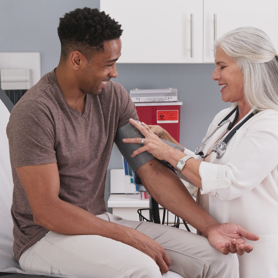 A healthcare professional checks a patient's blood pressure in a medical office.
