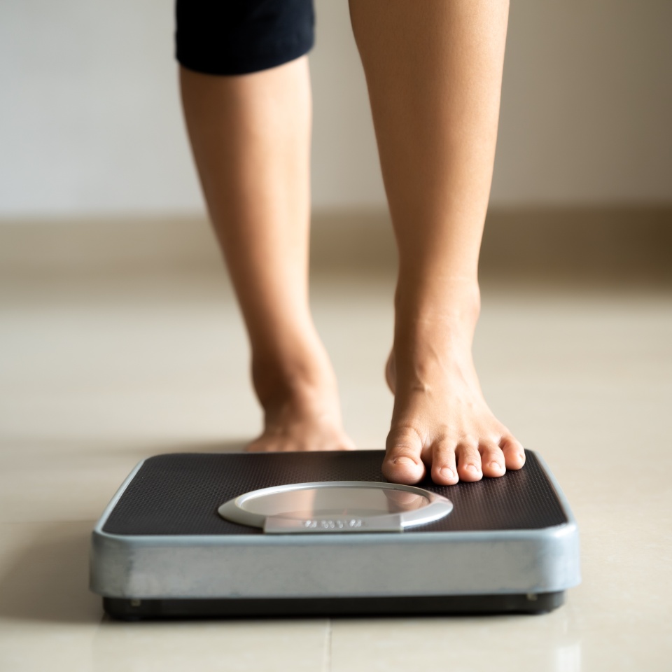 Female leg stepping on weigh scales. Healthy lifestyle, food and sport concept.