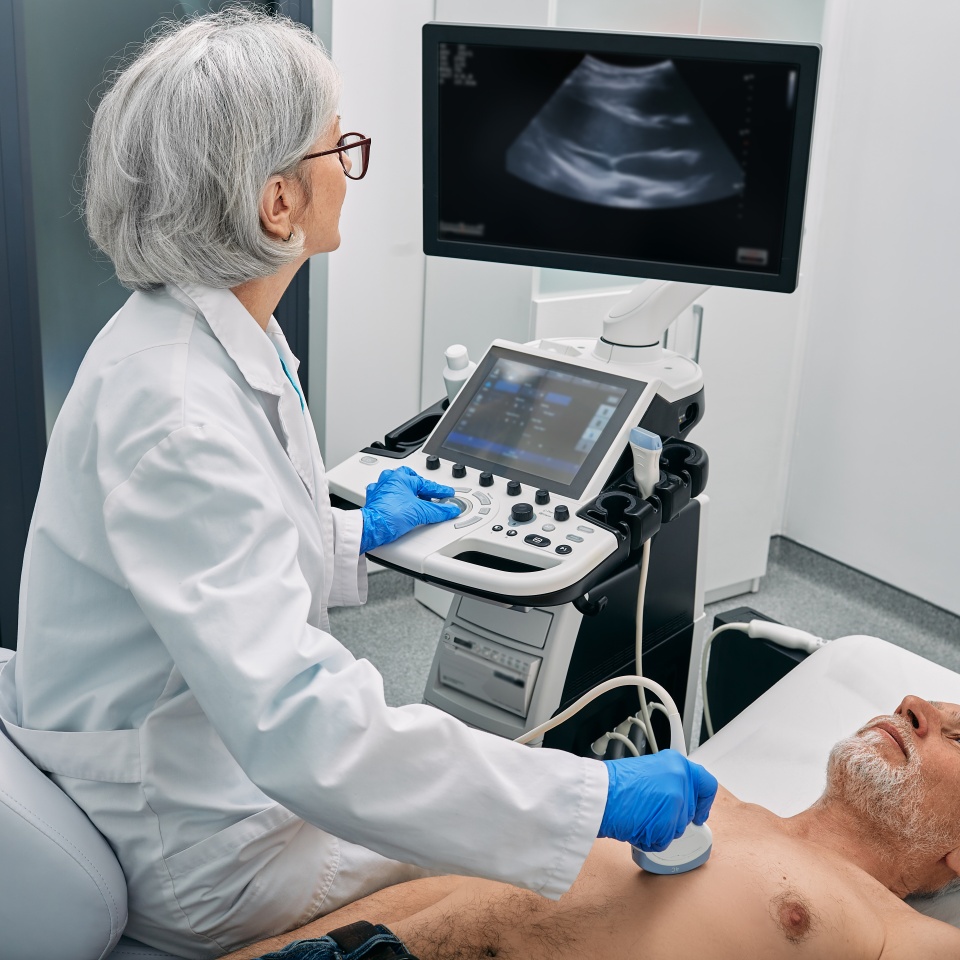 Heart ultrasound exam for senior man with ultrasound specialist while medical exam at hospital