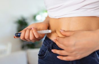A diabetic patient using insulin pen for making an insulin injection at home. Young woman control diabetes. Diabetic lifestyle