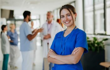 Portrait of young woman nurse at a hospital corridor.