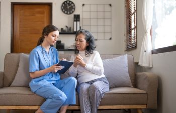 Asian nurse showing health checkup report to grandmather and giving advice. medical assisted living visit senior patient at home. Home nursing and healthcare caregiver concept