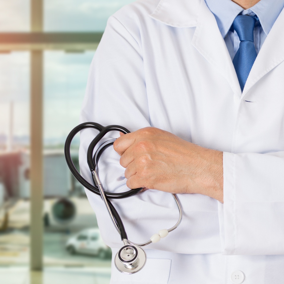 Cropped shot of a unrecognizable male doctor standing with his arms folded inside of a airport.Medical tourism concept