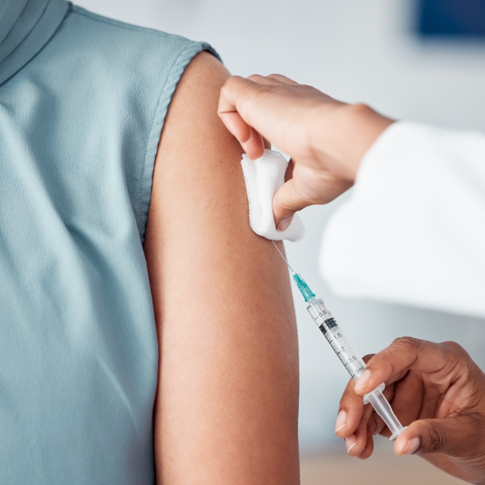 Hands, medical and doctor with patient for vaccine in a clinic for healthcare treatment for prevention. Closeup of a nurse doing a vaccination injection with a needle syringe in a medicare hospital