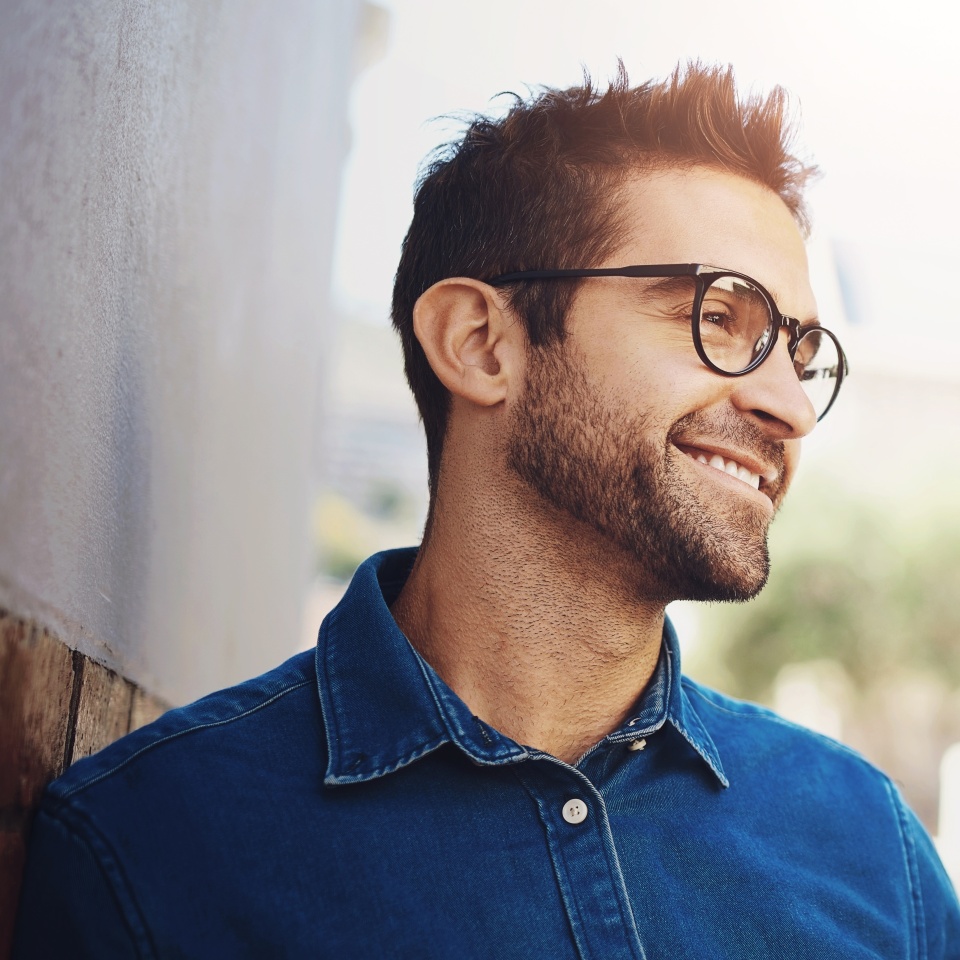 Thinking, smile and man with glasses, outdoor and happy with decision of studying in California and college. Street, city and person with vision for education, casual and writer with ideas in USA
