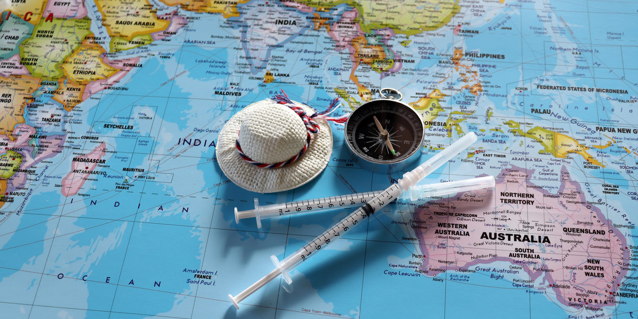 Needles for travel vaccinations on top of world map - MY CONCIERGE MD